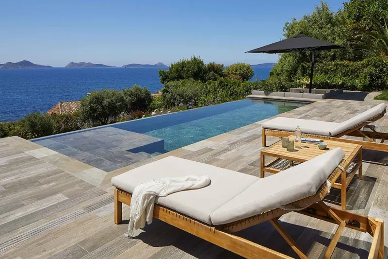 Piscina revestida de gres porcelánico con el borde abierto al paisaje